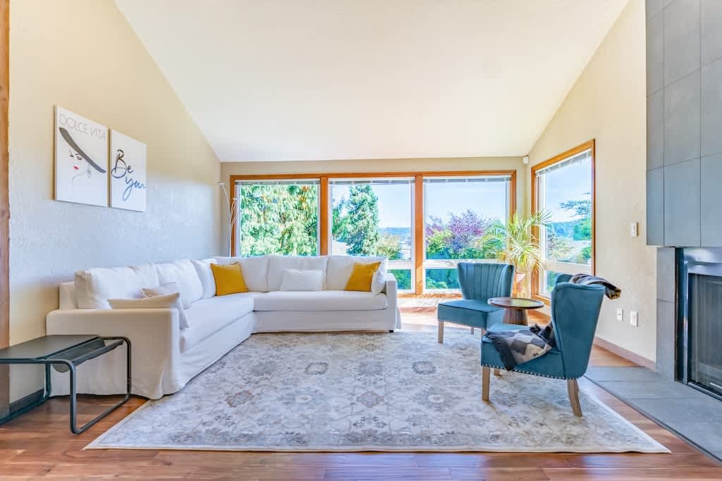 Spacious, well-lit living room filled with natural light and stunning views,  creating a breathtaking backdrop for relaxation and inspiration.