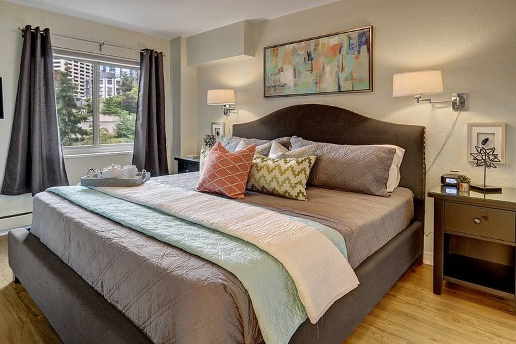 Modern bedroom with a plush king bed, stylish accents, and a view of the city skyline. Cozy, serene, and perfect for restful nights.
