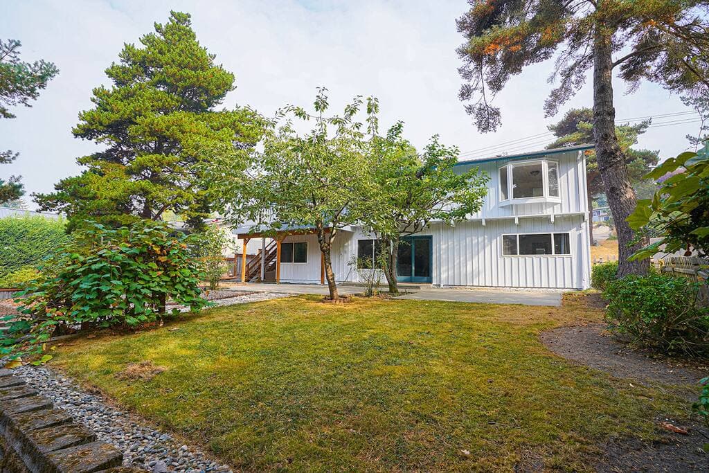 Deck overlooking the fully fenced yard of evergreen and fruit trees. Plenty of space for kids to run around