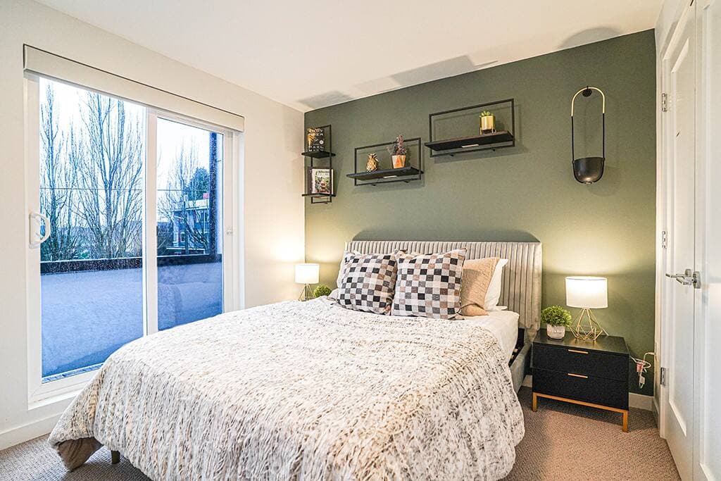 The master suite on the third floor features a queen-sized bed and is decorated with warm tones and soft textures for a comfortable and inviting atmosphere