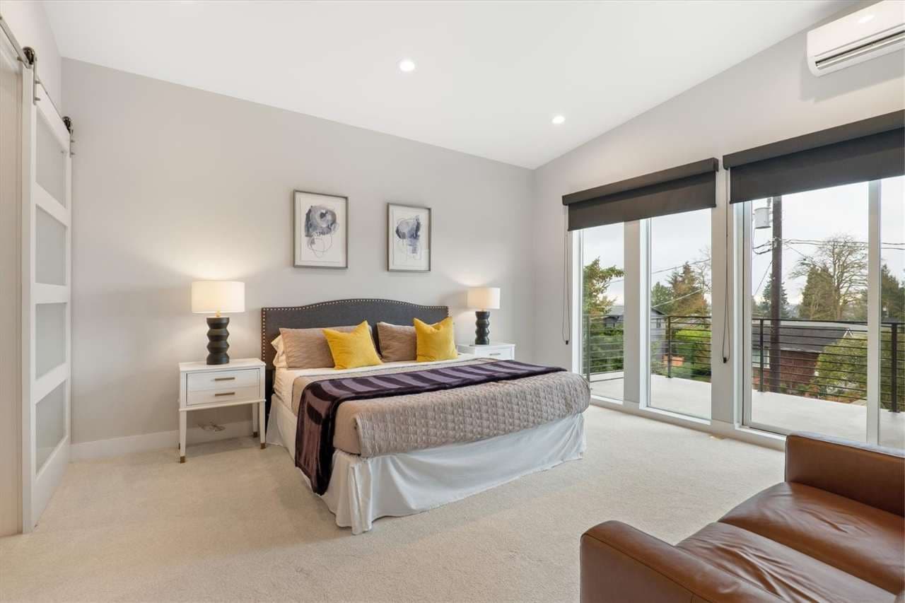 Spacious and serene bedroom with plush bedding, stylish nightstands, and a cozy armchair—opening out to a private balcony for a refreshing morning view.