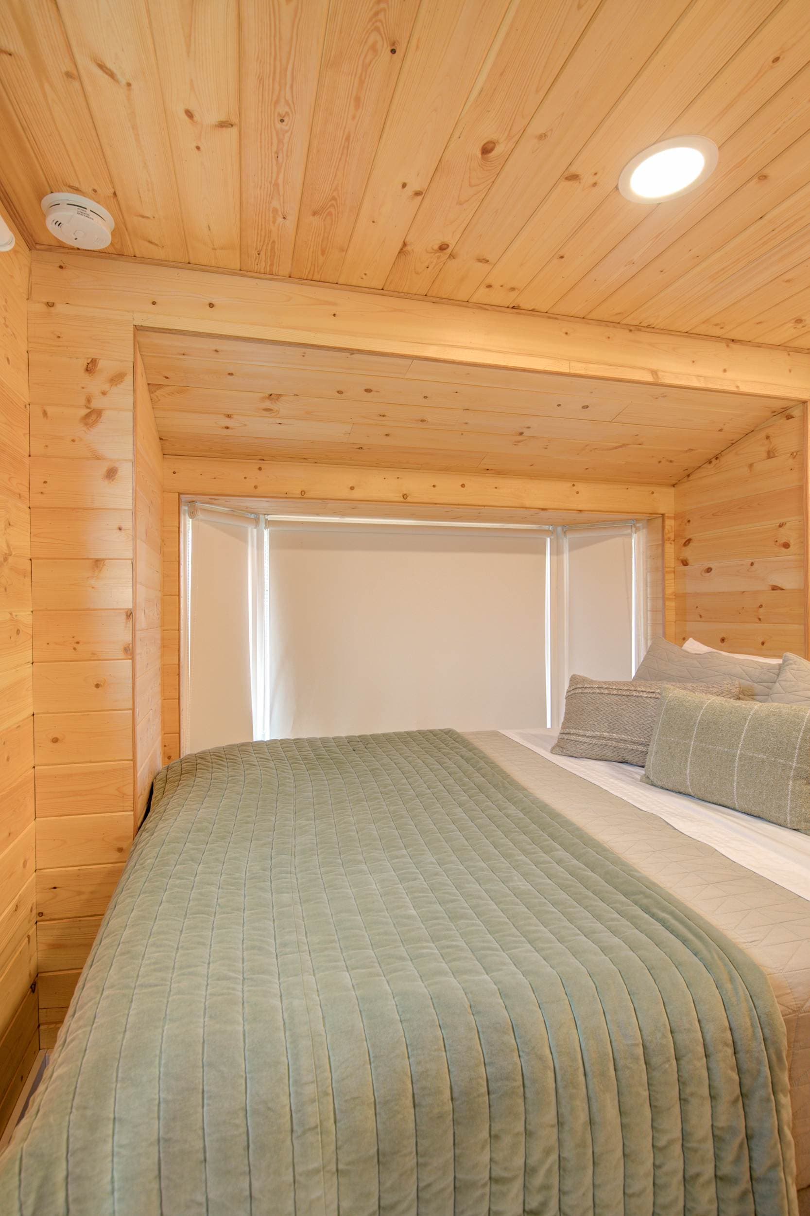Warm wood interior with a comfortable queen bed – a peaceful retreat.
