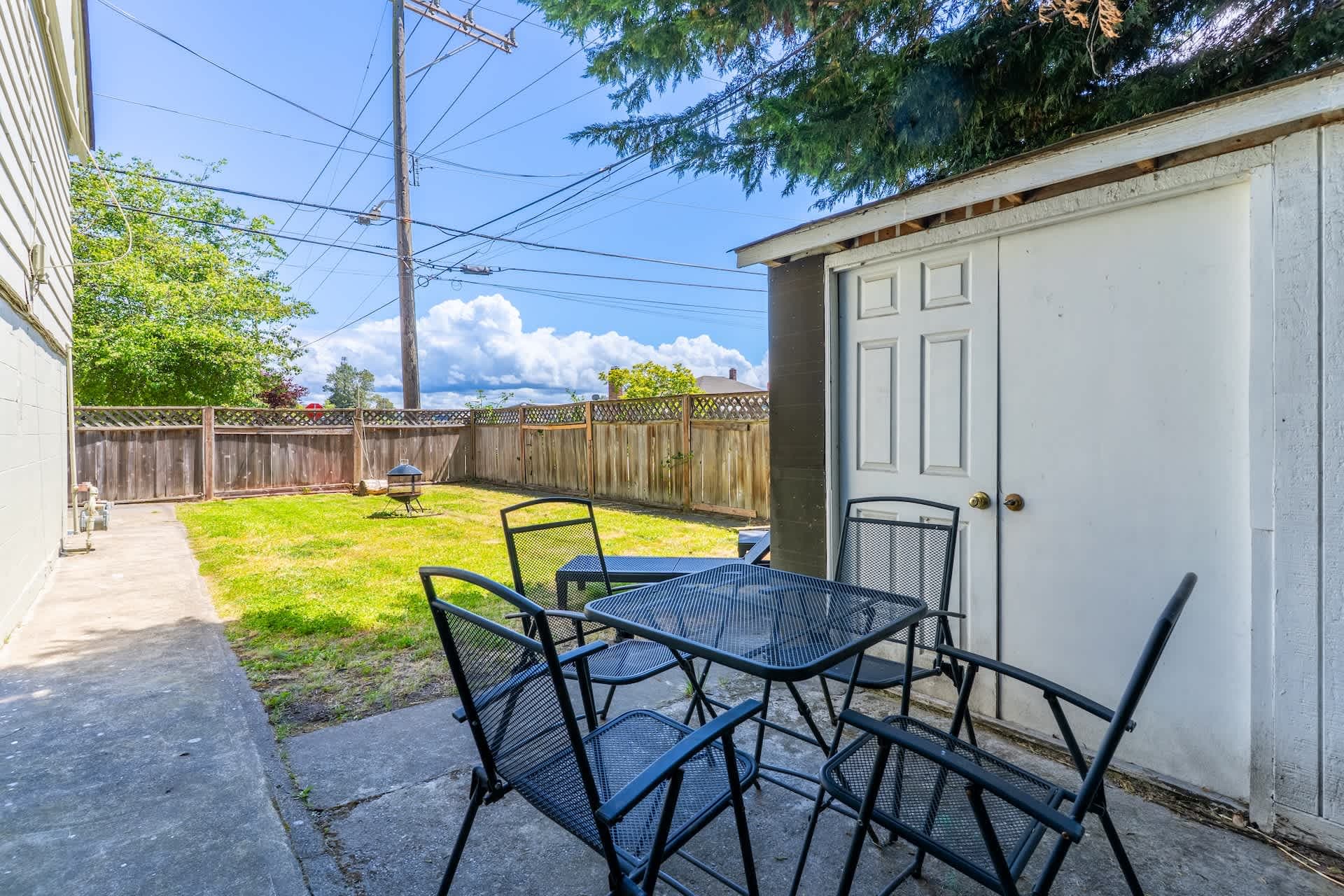 Spacious and serene, this private backyard features ample seating and a lush lawn. Ideal for outdoor dining and relaxation.